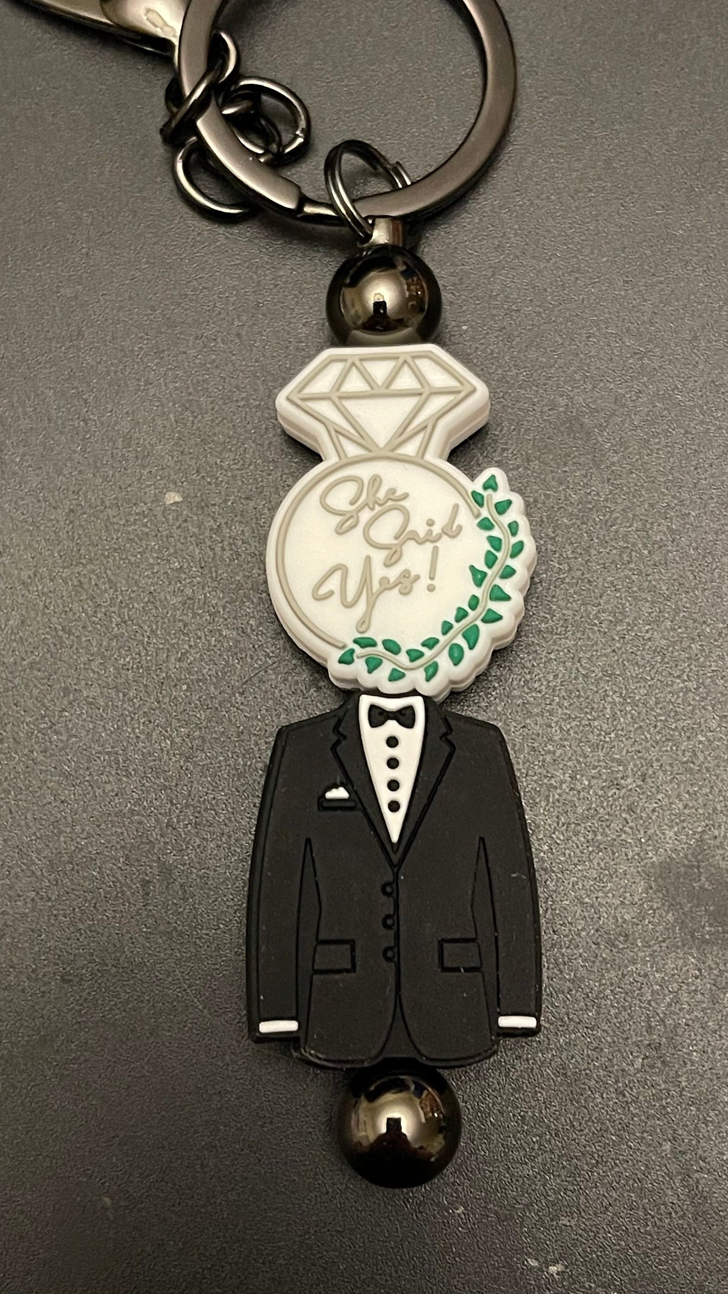 She said yes!  tux keychain or zipper pull. Also can put on purses or backpacks or any bag!